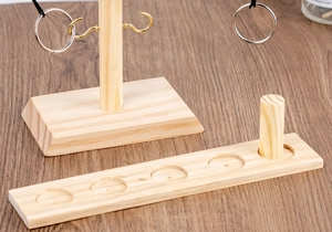 Close-up of wooden ring toss game components featuring a solid pine base and score pegs