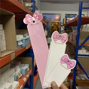 Pink and white paperboard hair accessory display cards with bow patterns and slots