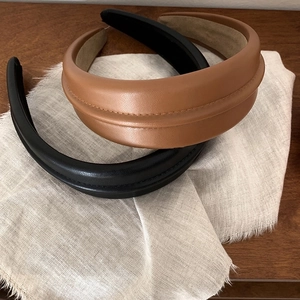 Premium padded leather headbands in brown and black on linen and dark wood background