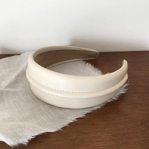 Detail of beige leather headband with elegant stitching and soft velvet lining