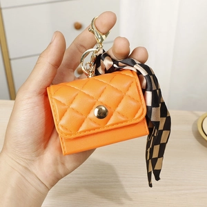 Mini orange quilted leather purse with gold hook and checkered ribbon accessory