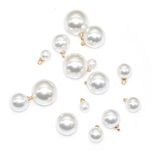 Detailed macro view of white ABS imitation pearl pendants with gold metal rings for DIY jewelry
