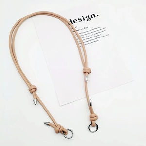 Detail of pink PU leather bag strap with silver metal buckles and decorative knot design