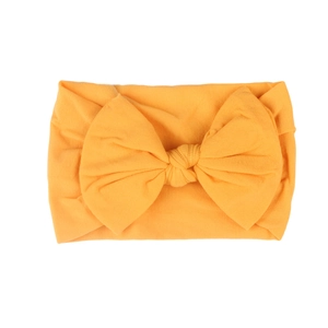 Macro shot of orange nylon bow headband showing the soft knitted fabric texture