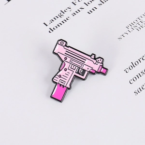 Cute pink Uzi submachine gun metal pin badge with black outlines on text background