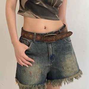 Vintage embossed brown leather belt styled with denim shorts and a printed crop top