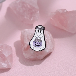 Cute white ghost enamel pin with purple pumpkin basket and floral wreath on pink crystals