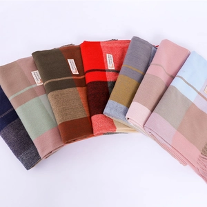 Detail view of multicolored cashmere blend scarves with tassels and check patterns