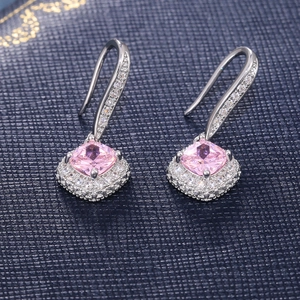 Detail of square pink zircon drop earrings with halo micro-pave setting on blue leather