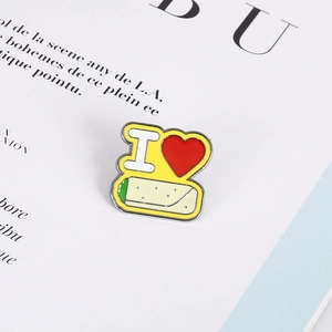 Detailed close-up of an I Love Burrito enamel brooch on a stylish magazine page