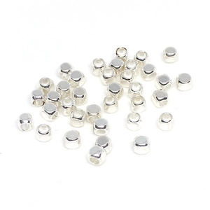Bunch of silver-colored square spacer beads made of solid metal on a white background
