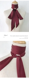 Detail of wine red silk scarf tied as a choker and bow knot on a mannequin neck