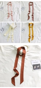 Detail showing solid color slim silk scarves in pink, brown, beige, and brick red