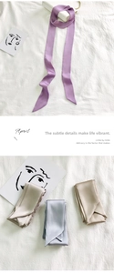 Detailed view of narrow satin scarf textures with elegant double-layer stitching and tapered ends