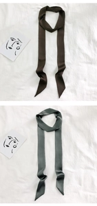 Close-up of narrow satin twilly scarves in dark brown and sage green for bags