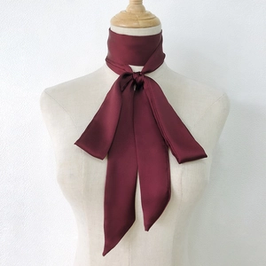Elegant wine red narrow silk scarf tied around neck on a mannequin with glossy finish