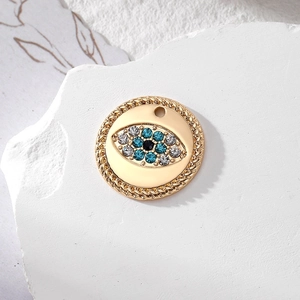 Detailed macro view of a golden evil eye charm with blue and white rhinestones