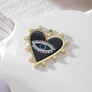 Gold heart evil eye pendant with pearls and colorful beads on a white pedestal