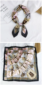 Detail of silk square scarf with vintage chain and tassel pattern on white fabric