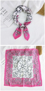 Detail of satin square scarf with pink borders and baroque floral patterns on white fabric