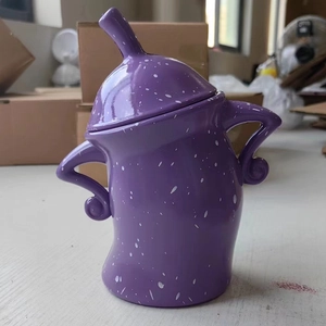Detail view of a purple ceramic canister with white spots and playful curved handles