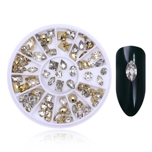 Detail view of gold and crystal nail art rhinestones in a white storage organizer box