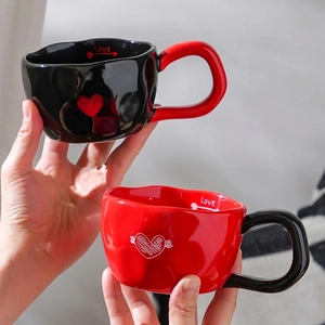 Minimalist ceramic heart mugs in black and red with textured wavy design for couples