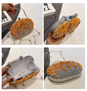 Detail view of silver clutch bag with orange sequins, metal frame, and chain strap