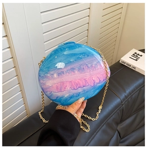Detail of blue and pink marble acrylic clutch bag with a golden metal chain strap