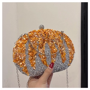 Close-up of orange shell tiles and silver rhinestone inlay on pumpkin-shaped evening bag