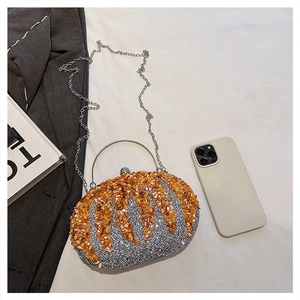 Detailed view of silver evening bag with sparkling orange sequins and metal handle