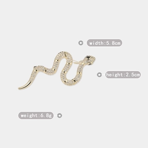 Detail view of gold snake brooch with crystal zircon showing 5.8cm width and 2.5cm height