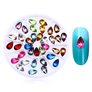 Detail of colorful teardrop nail rhinestones in a circular case with application example
