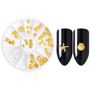 Detailed nail art set with gold ocean charms and application on dark nails