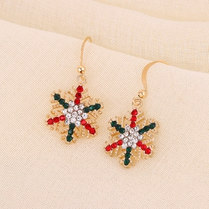Detailed view of Christmas snowflake drop earrings with red and green rhinestones