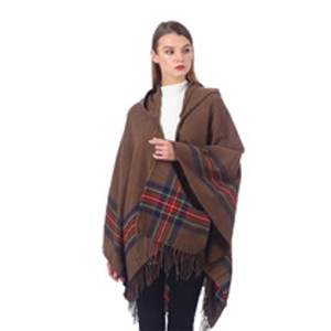 Detail of brown knitted poncho featuring tartan plaid pattern and decorative fringe trim