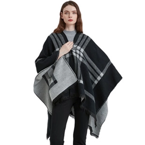 Detail of black and grey plaid poncho featuring decorative fringe edges on the fabric