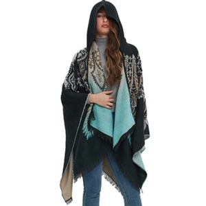 Detail of hooded poncho featuring ethnic patterns, fringe hem and vibrant teal accents