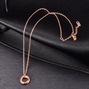 Detailed view of rose gold interlocking triple rings on a fine chain necklace