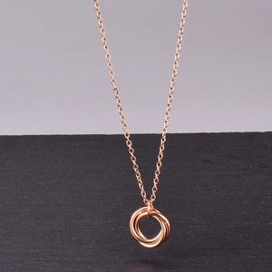 Minimalist 18K rose gold necklace with three interlocking rings pendant on a fine chain