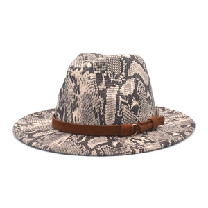 Detail of fedora hat featuring monochrome snake print and brown suede band with gold ring