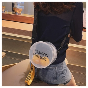 Detail view of round transparent jelly crossbody bag with yellow straps and fashion print