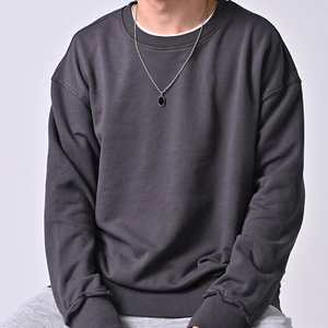 Künstlerische Silberhalskette mit Edelsteinanhänger auf grauem Rundhals-Sweatshirt