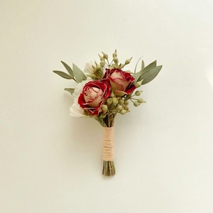 Close-up of red and white dried roses boutonniere with eucalyptus and hemp rope