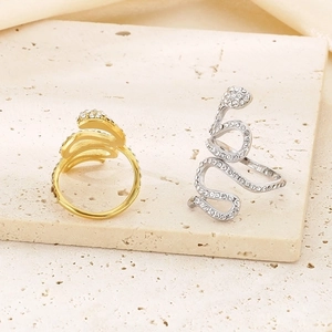 Close-up of gold and silver snake rings with cubic zirconia on travertine stone