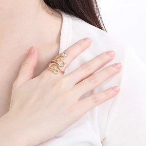 Detailed close-up of a snake-shaped gold ring with white rhinestones on a hand