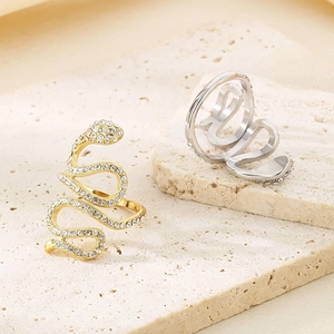 18K gold and silver snake rings with crystal pavé on textured stone display