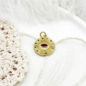 Macro shot of evil eye pendant with red marquise stone on white feather background