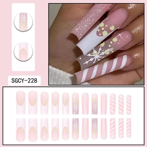 Christmas press-on nails with pink base, white snowflakes, and candy cane stripes