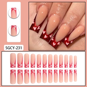 Long coffin false nails featuring nude and red pearlescent french heart patterns